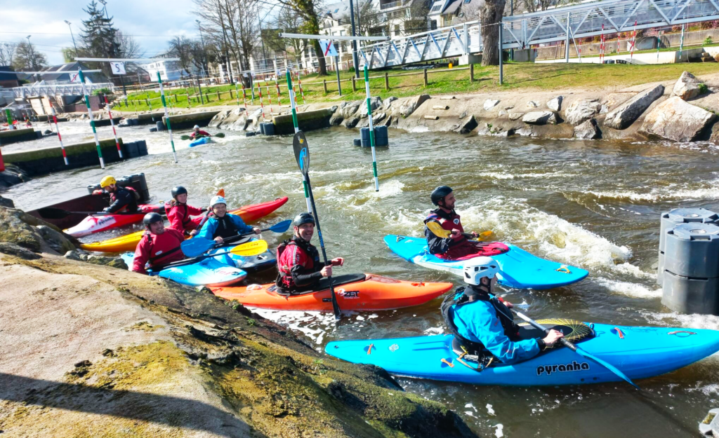 Groupe de kayakistes adultes loisirs navigant sur l'eau du stade d'eau-vive
